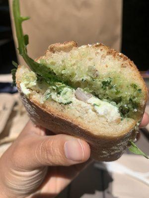 Goat cheese sandwich on baguette with pesto and arugula