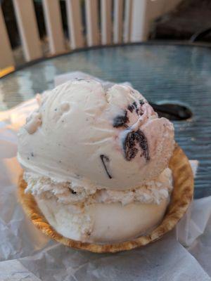 A double scoop and a waffle cone cup. Pistachio in the bottom and vanilla cherry on the top