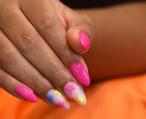 Hot pink nails with playful star accents for a vibrant, youthful look. #PinkStars #NailArtFun