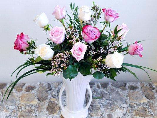 A dozen premium long stem roses are a show-stopping sight in this gorgeous white ceramic urn. Lavender, Pink and White Roses are accented by