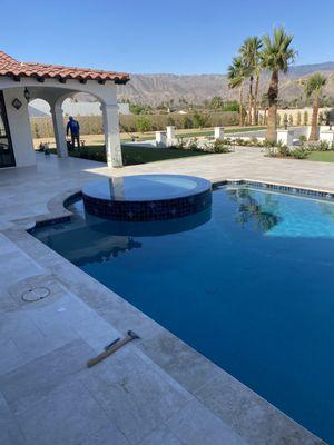 New pool with infinity spa and travertine coping