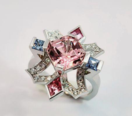 Center stone: 3.23ct. Asscher-cut tourmaline flanked by blue princess and pink kite-shaped sapphires, with diamond accents.