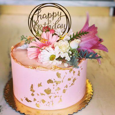 Pink cake with fresh flowers and gold accents