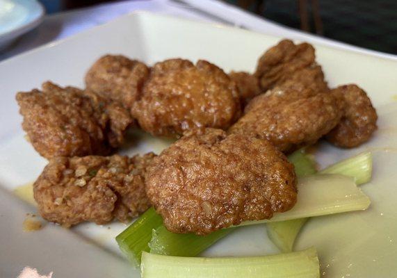 Boneless chicken wings with a garlic butter sauce with celery