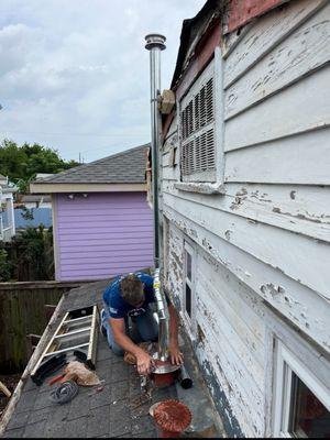 NoLa Flow crew installing new hot water heater chimney; bringing it up to city code