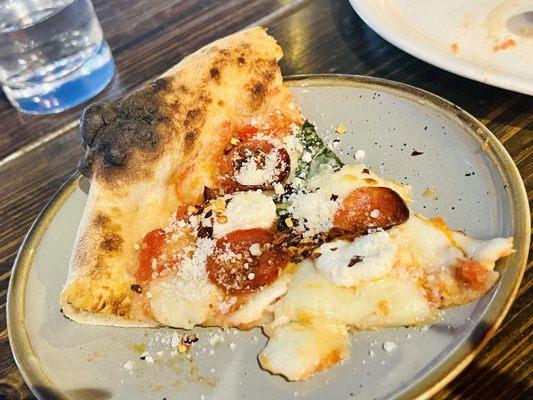 A slice of the margherita with crushed pepper and parmesan