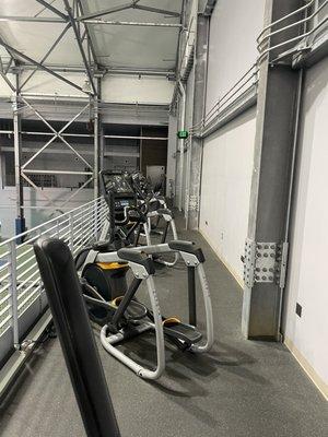 Workout machines upstairs overlooking tennis courts