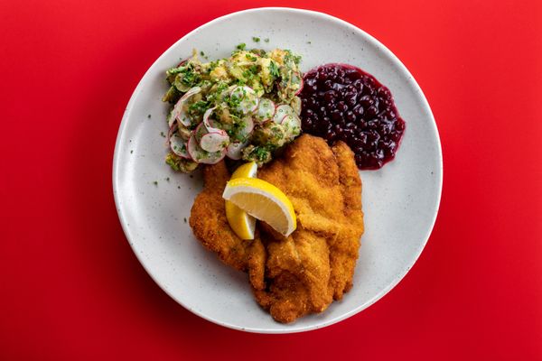 Schnitzel: tenderized breaded veal or pork cutlet served with lingonberry and a choice of potato salad or seared potatoes.