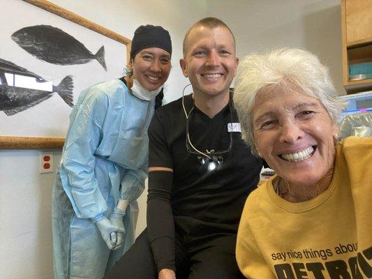 JC, Dr. Trevor Hartwell & Emily. Last 7 months wearing clear removable retainer with my teeth from prior bridge . Replacing with implants.