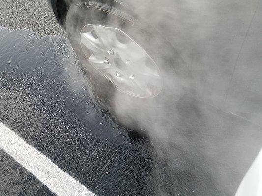 The heat from the tire after he poured water on it to cool it.