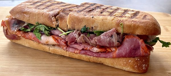 Daniele - panini - Prosciutto, Sopresatta, cappicollo, fresh mozzarella, Arugula, vine ripe tomatoes, evoo, Balsamic, w/ pickle & chips