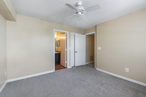 Bedroom with carpet flooring, multi speed ceiling fan, and in-suite bathroom