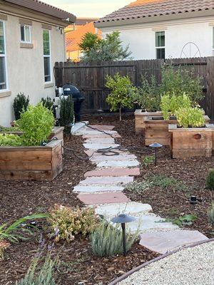 Our stone walkway to the redwood planter's that we use for herbs, vegetables and fruits!