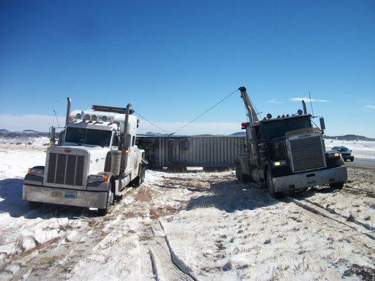 Two heavy duty wreckers righting a semi truck through airbag recovery.