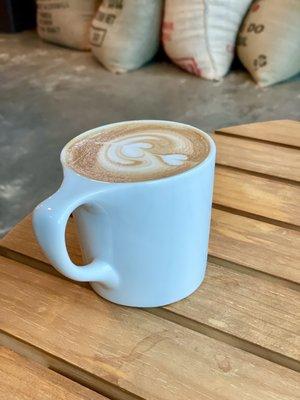 Orange cardamom latte by the back window facing the river.