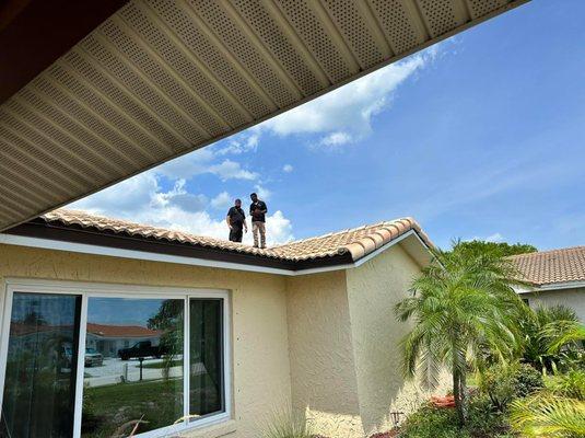 A roof inspection with a professional standing on the roof in Brevard County Fl, highlighting the importance of evaluating ro...