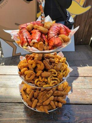 Seafood tower includes: Brown sugar hush puppies, fries, fish, scallops, shrimp AND calamari