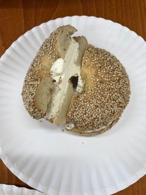 Sesame bagel with plain cream cheese - seeds on top and bottom