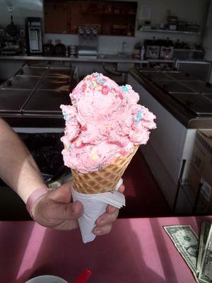 Delectable strawberry with jolly ranchers in waffle cone