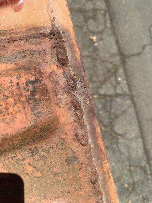 Rusty roof with pinholes in welds