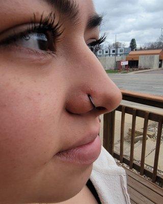 Nose piercing with hoop jewelry.