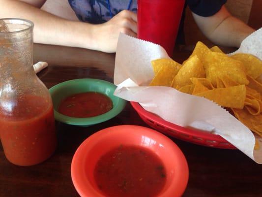 Complimentary chips and salsa with horchata in the background.