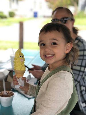 Banana soft serve on a cone with a face.