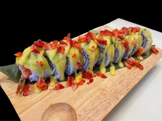 Tropical roll!! tempura shrimp, crab, cream cheese, and cucumber inside with mango, kiwi, strawberries on top with a mango sauce drizzle.