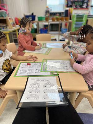 Children engaged using worksheets and "reusable learning mats", making them suitable for repeated practice.