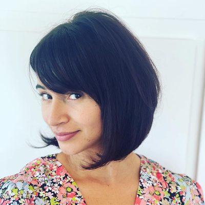 A classic bob haircut with a sweep fringe and rich espresso brown color