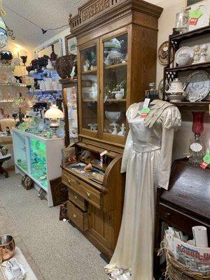 Wedding dress is on its way to be used again. 1880's oak cylinder desk, chest, hutch needs a new home. Vaseline glass glows in corner