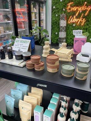 Fancy bath products in front of instagrammable neon and greenery "Everyday Works" sign.