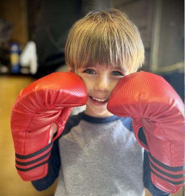 Check out the joy when a child puts on their first pair of boxing gloves!