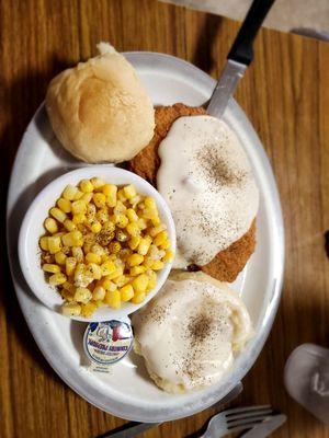 Smothered chicken fried steak, msshed potatoes, corn, and homemade roll.