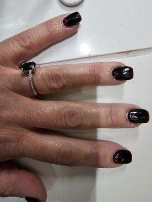 Black nails tipped in red and red hearts at base.