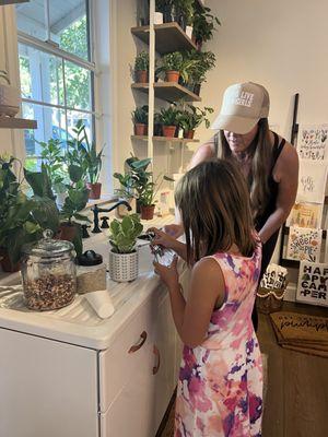 Tiffany showing my daughter how to pot her own plant!