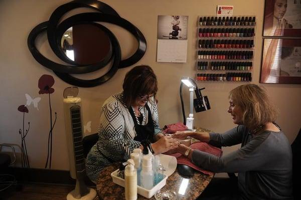 Jolela Stinnett, left, files Jackie Writz's nails as she gives her a manicure at J. Lyn and Friends A Salon in Littleton on Sept. 18, 2014