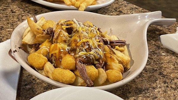 Poutine.  Potato scoops, cheddar cheese balls, roast beef and gravy, and shredded cheese.