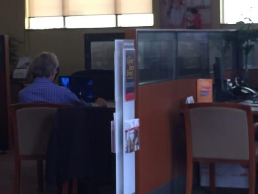 Anther guy playing on desk where bankers used to sit.  His own laptop ostensibly