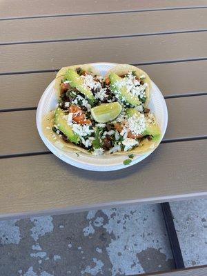 Carne asado tacos with avocado, tomato, and cheese extra.