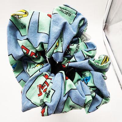 Monopoly XXL Scrunchie: Game on for Style!  Elevate your look with our larger-than-life scrunchie, inspired by the iconic Monopoly bo