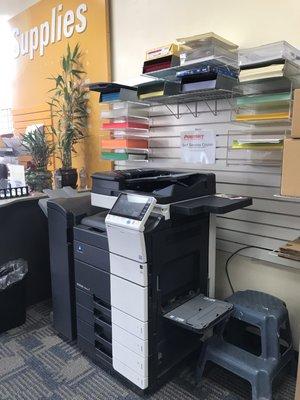 One of the copy machines with various colors and types of paper