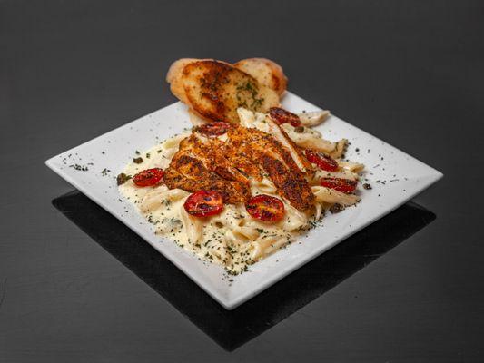 Cajun chicken Alfredo, penne pasta, blistered tomatoes, fried capers, and crostini