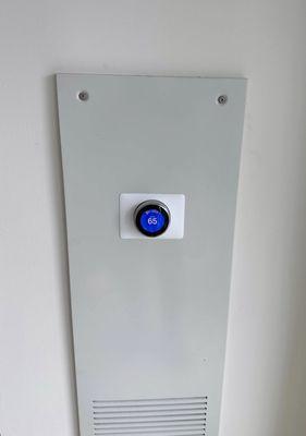 Installed and programmed a Nest Learning Thermostat mounted on a white Wall Plate.