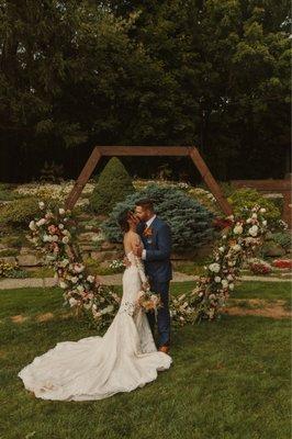 Hexagon wedding arch decorated with flowers.