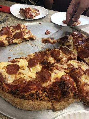 Large pepperoni pizza being shared inside Lena's.