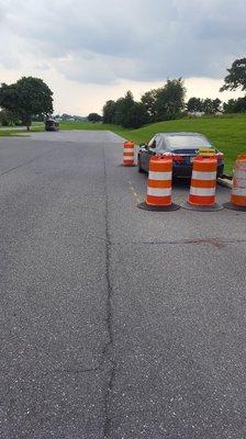 Use the crack beside the barrels to line your car up 3 feet away at the Brownstown DMV