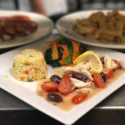 Salmon and crabmeat with cherry tomatoes and Kalamata olives served with a side of rice and spinach mixed with carrots and zucchini