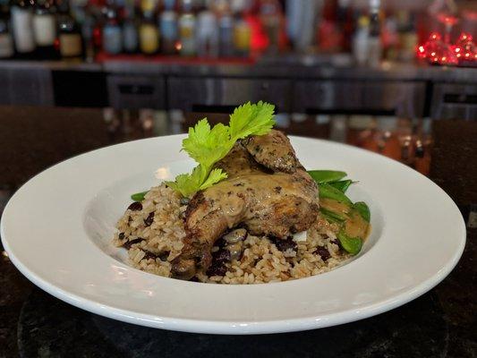 Chef's Parnell's Special Jerk Hen over seasoned beans and rice.