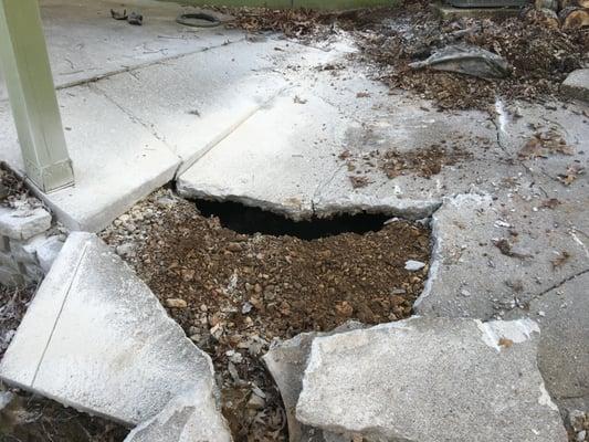 The dark shadow in the middle of the picture under the edge of the concrete is a collapsed metal septic tank...